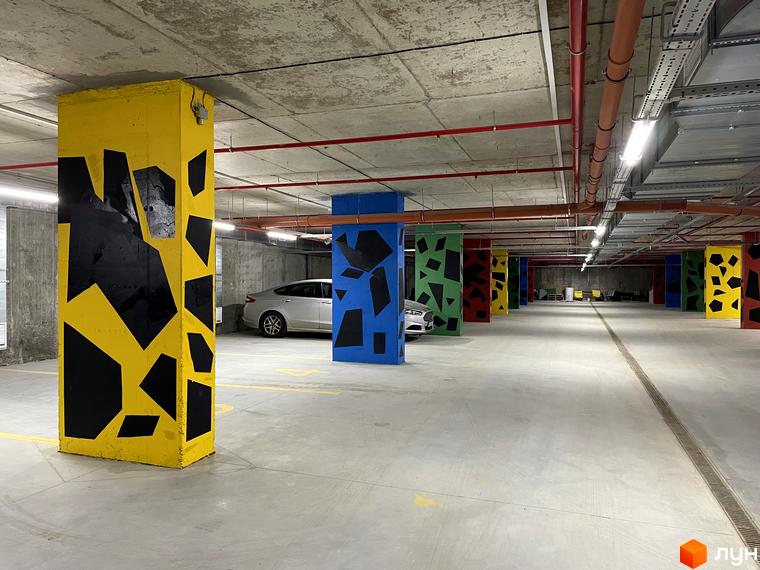 Паркінг у житловому комплексі Villa Magnolia Spring з яскраво розфарбованими колонами та автомобілями. Огляньте підземний паркінг вашого майбутнього дому.