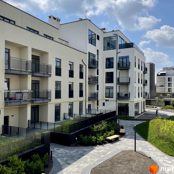 Зовнішній вигляд новобудови ЖК Villa Magnolia Spring з балконами та вікнами. Прибудинкова територія з ландшафтним дизайном та місцями для відпочинку.