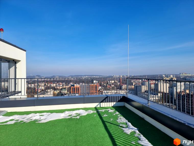 Вигляд з даху Житлового комплексу Вільне Місто на місто. На даху штучний газон та сніг, видно огорожу.