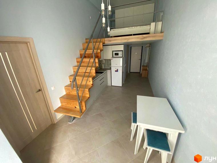 Житловий комплекс Сузір'я 2020: інтер'єр квартири-студії з кухнею, сходами на другий поверх та обідньою зоною.