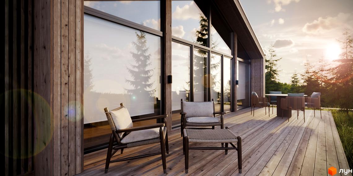 Зовнішній вигляд будинку KM Greenhill chalet з дерев'яними елементами та великими вікнами, що виходить на терасу з меблями та лісовий пейзаж.