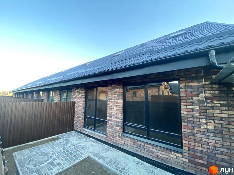 Котеджне містечко Панська Баварія: цегляний будинок з великими вікнами та бруківкою на прибудинковій території. Зовнішній вигляд новобудови.