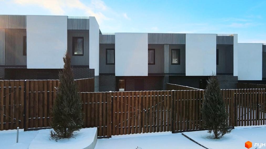 Таунхаус Новоолександрівський: фасади з білими та сірими панелями, вертикальне оздоблення, вікна, дерев'яна огорожа, ялинки та сніг на території.