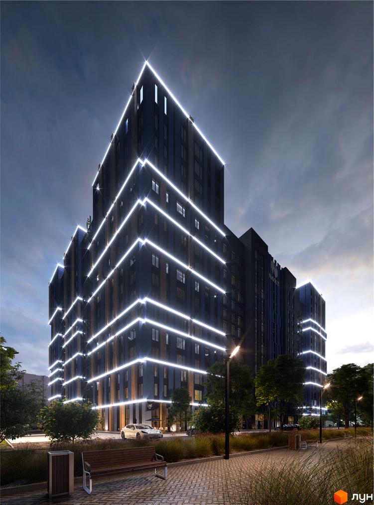 Житловий комплекс One House ввечері, з темними фасадами, прикрашеними світлими горизонтальними лініями. Прибудинкова територія має доріжки, дерева та лавки.