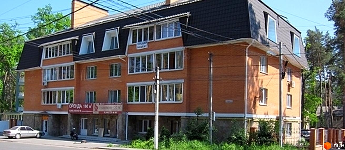 Житловий комплекс на вул. Пушкінська, 43, з цегляною фасадною частиною та великими вікнами. Прибудинкова територія озеленена та облаштована.