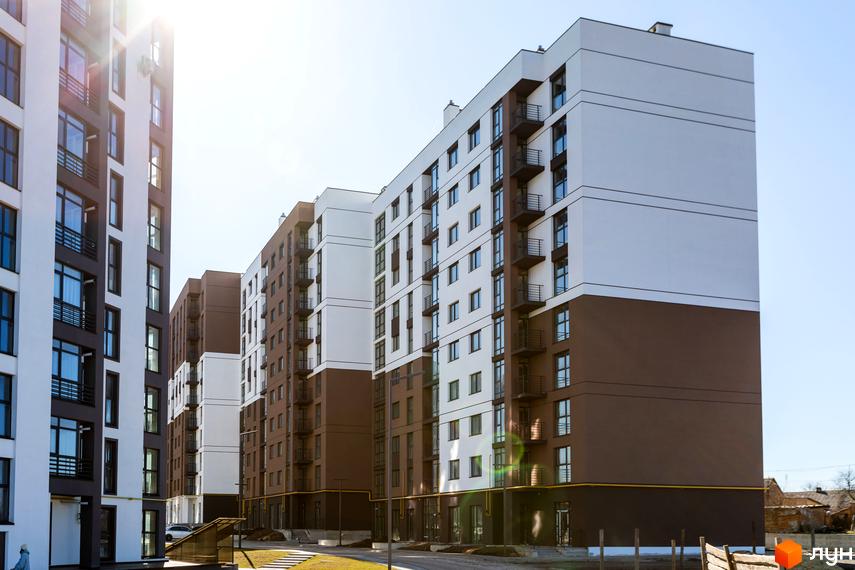 Новобудова ЖК Супернова з біло-коричневими фасадами та балконами. Навколо будівельний майданчик та зелена зона.