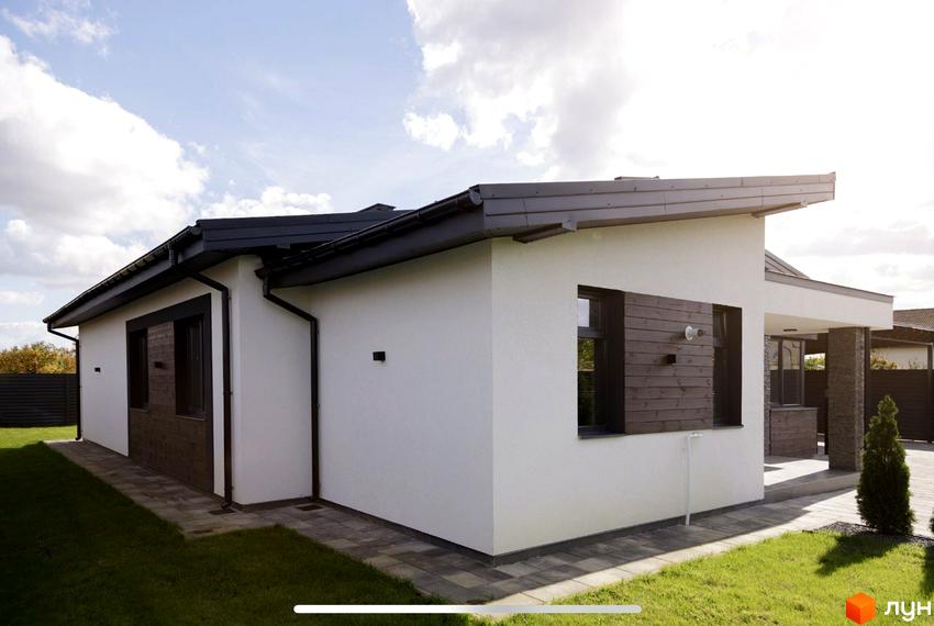 Зовнішній вигляд одноповерхового будинку з білими стінами та темним дахом на вулиці Мазепи. Прибудинкова територія з газоном та бруківкою.