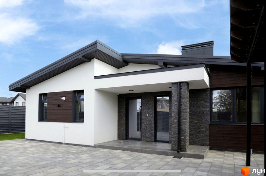 Сучасний житловий комплекс на вул. Мазепи. Зовнішній вигляд будинку з білою штукатуркою, темним дахом та дерев'яними елементами, вимощена плитка на прибудинковій території.