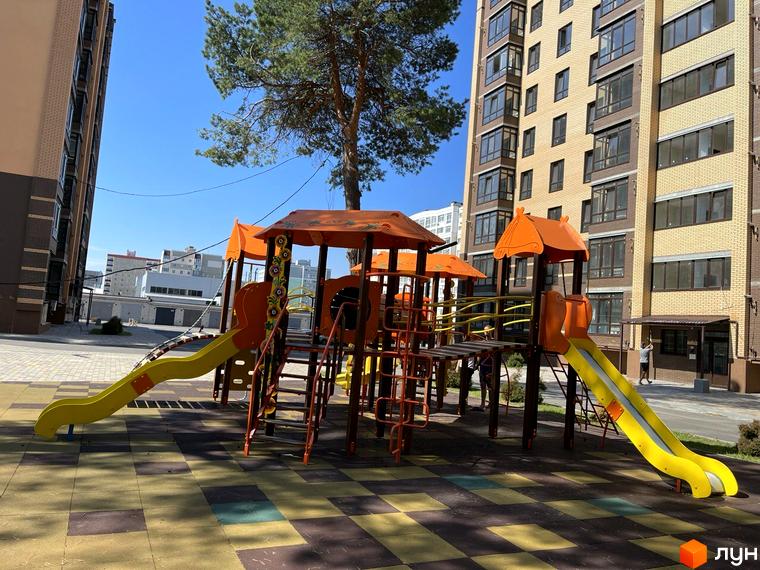 Житловий комплекс Масани: дитячий майданчик з гірками на фоні багатоповерхових будинків.