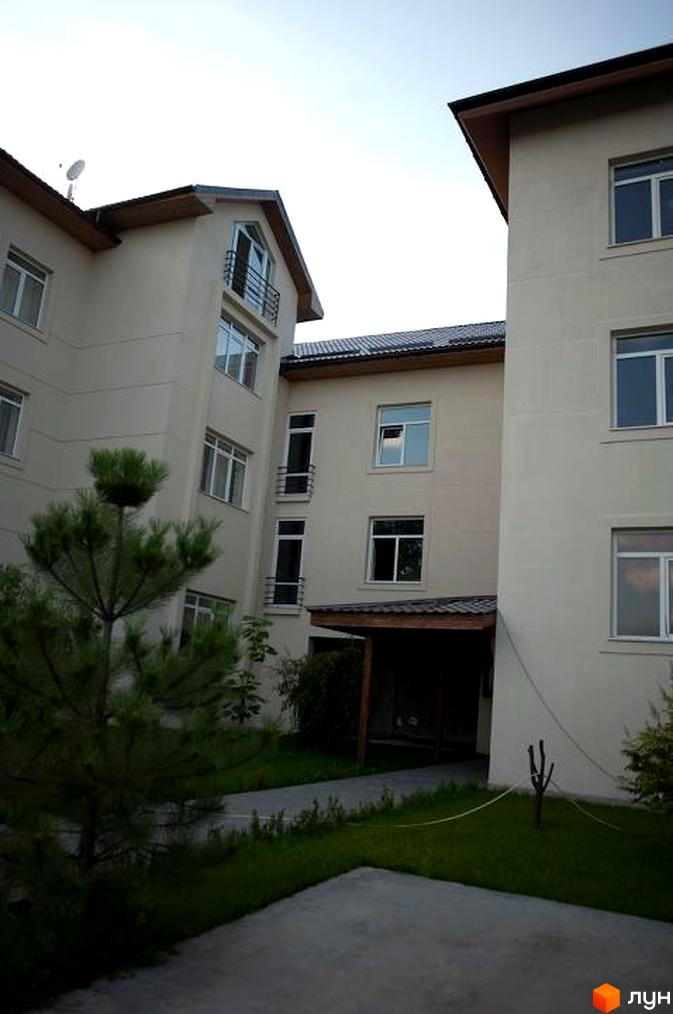 Житловий комплекс Бірюза: фасади будівель з вікнами та балконами, прибудинкова територія з деревами та газоном. Зовнішній вигляд новобудови.