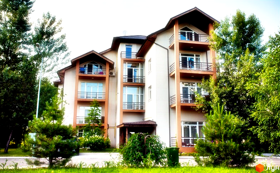 Житловий комплекс Бірюза - це багатоповерхова будівля з балконами та великими вікнами, оточена зеленню та деревами. Навколо комплексу доглянута прибудинкова територія з газонами.