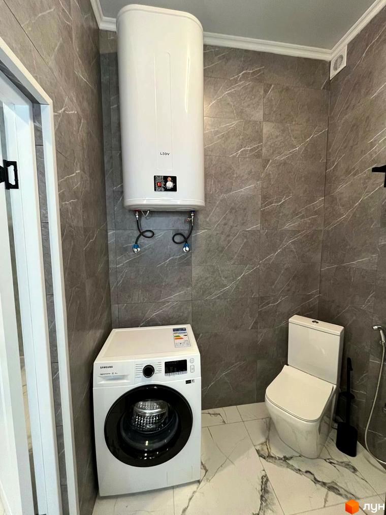 Інтер'єр ванної кімнати з пральною машиною, бойлером та сантехнікою в ЖК Лелека. Сучасне планування та функціональність для комфортного життя.