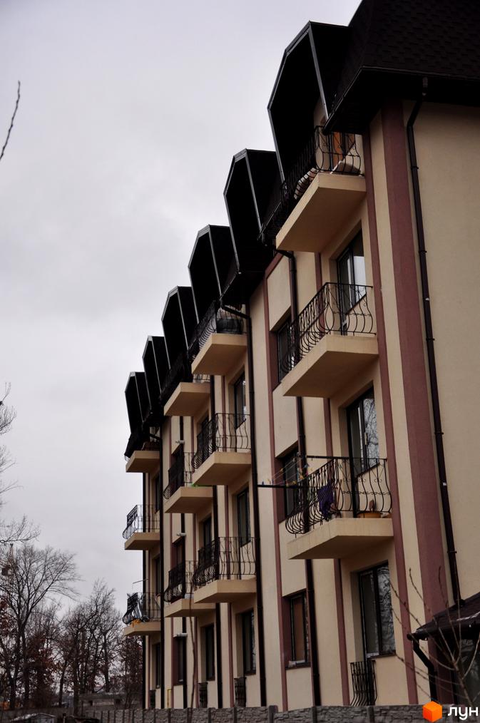 Житловий комплекс на вул. Червоноармійська, 14. Будинок з балконами та прибудинковою територією з зеленими насадженнями.