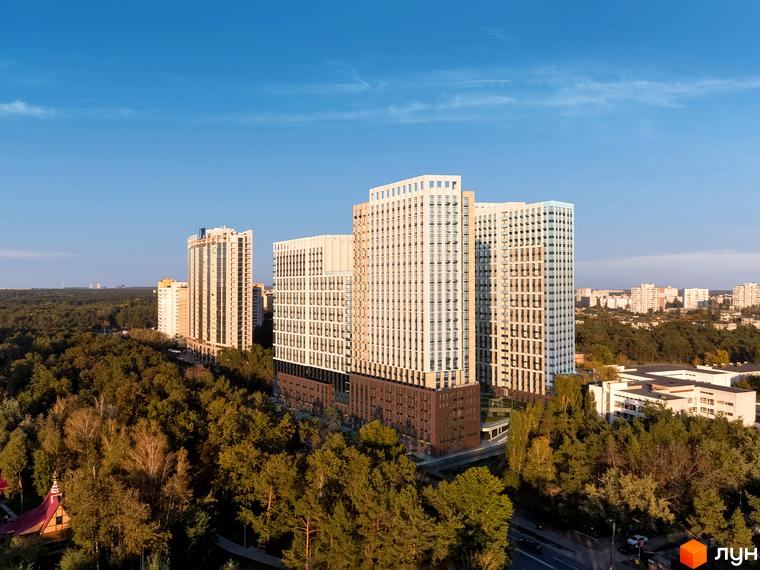 Новобудова ЖК Новий Автограф - це сучасні багатоповерхові будинки з панорамним склінням, розташовані серед зеленої зони. Комплекс оточений деревами, що створює затишну атмосферу.