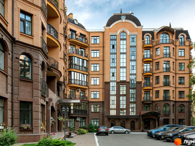 Житловий комплекс Соборний з фасадом з червоної цегли та балконами. Прибудинкова територія з парковкою та зеленими насадженнями.