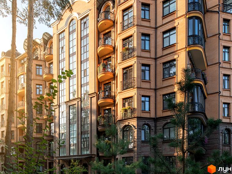 Житловий комплекс Соборний з великими вікнами та балконами, оточений зеленими насадженнями та деревами.