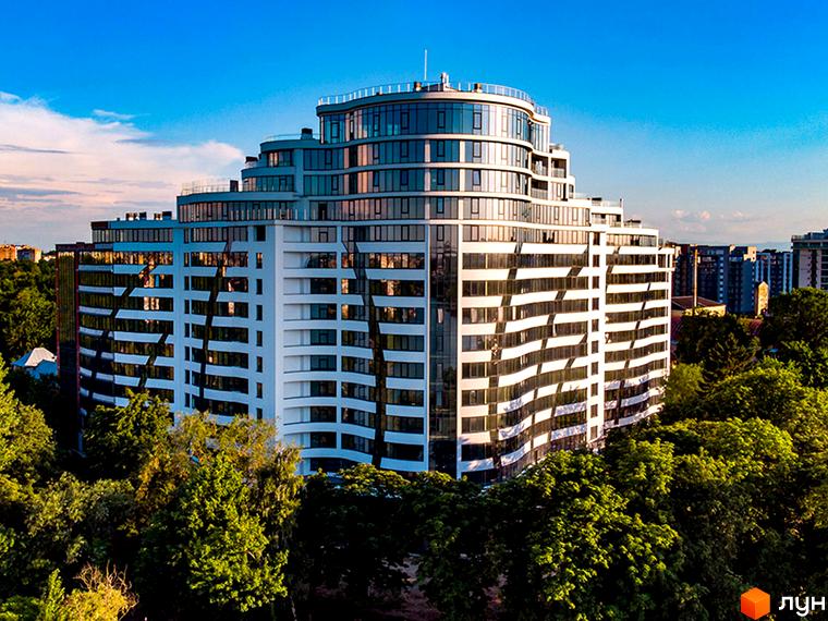 Зображення Житлового комплексу Parus. Багатоповерхова будівля з великою кількістю вікон, навколо дерева та зелені на прибудинковій території.