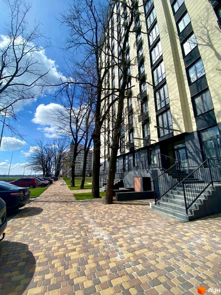 Житловий комплекс Park Plaza має світлі фасади та великі вікна. Прибудинкова територія облаштована бруківкою, зеленими газонами та деревами.