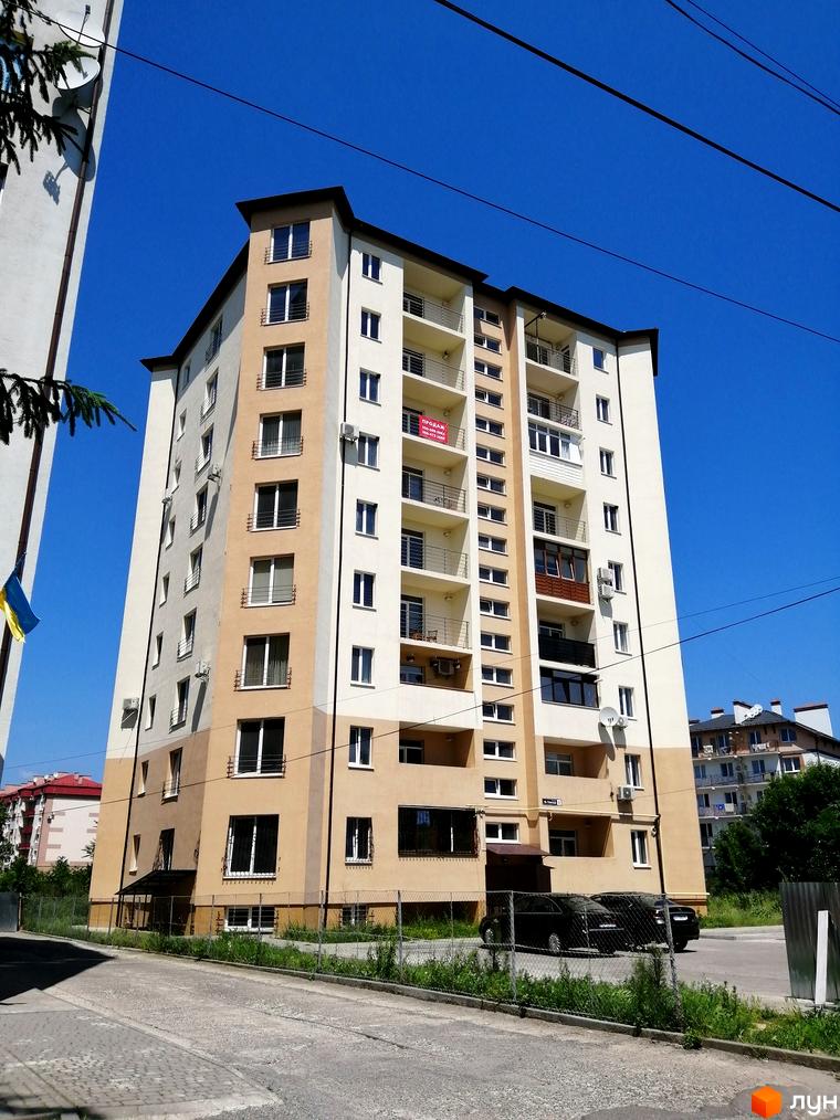 Багатоповерховий житловий комплекс на вул. Гленца, 14, з бежево-білим фасадом та балконами. На прибудинковій території видно паркування та зелені насадження.