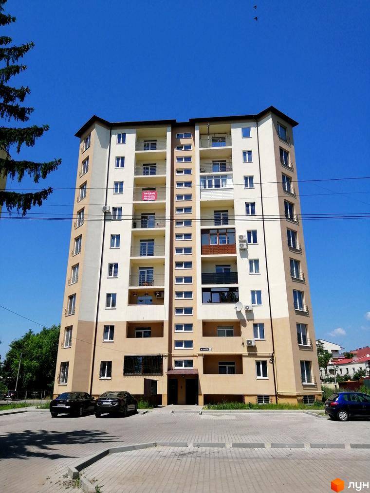 Багатоповерховий житловий комплекс на вулиці Гленца, 14, з балконами та кондиціонерами. Перед будинком розташована парковка з автомобілями та зелені насадження.