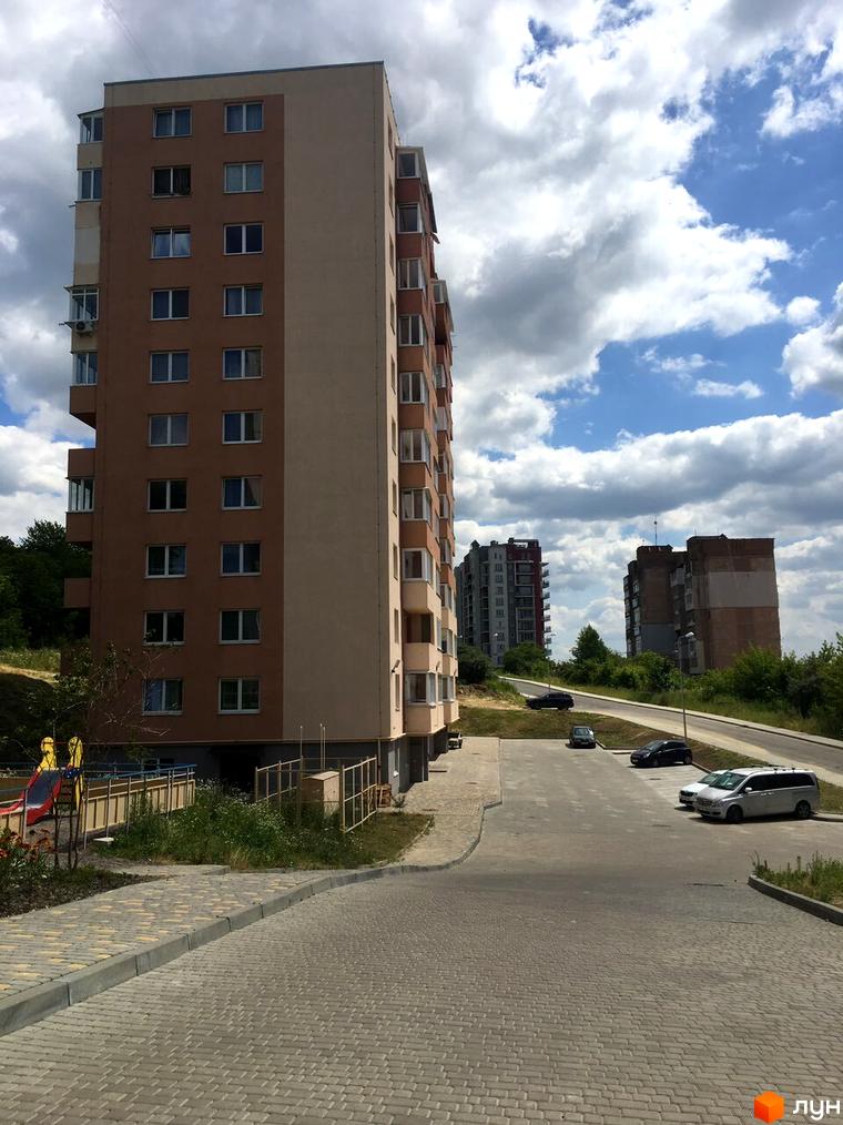 Зовнішній вигляд багатоповерхового будинку на вулиці Джона Ленона, 1, 3. Прибудинкова територія з дорогою та парковкою.