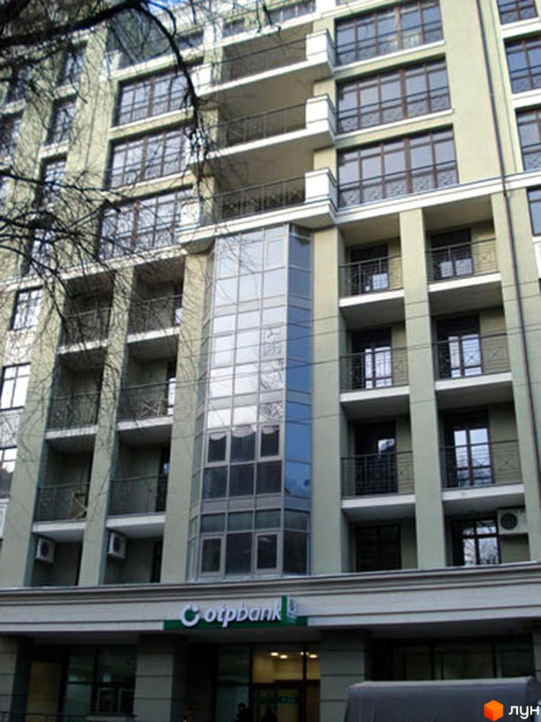 Житловий комплекс на вул. Чернишевська, 7 з великими вікнами та балконами. Прибудинкова територія з зеленими насадженнями.