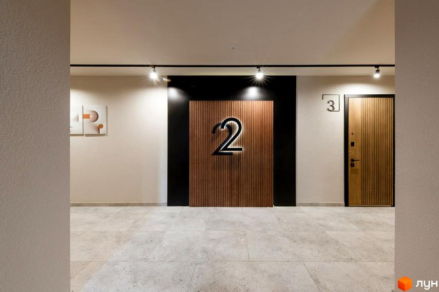 Житловий комплекс SHERWOOD: двері з дерев'яними панелями та номер 2 на стіні. Сучасний дизайн вхідної групи.