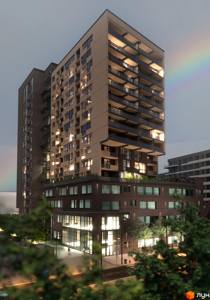 Зовнішній вигляд житлового комплексу AUROOM AIR з балконами та вікнами, освітленими ввечері. На передньому плані видно дерева та дорогу з пішоходами.