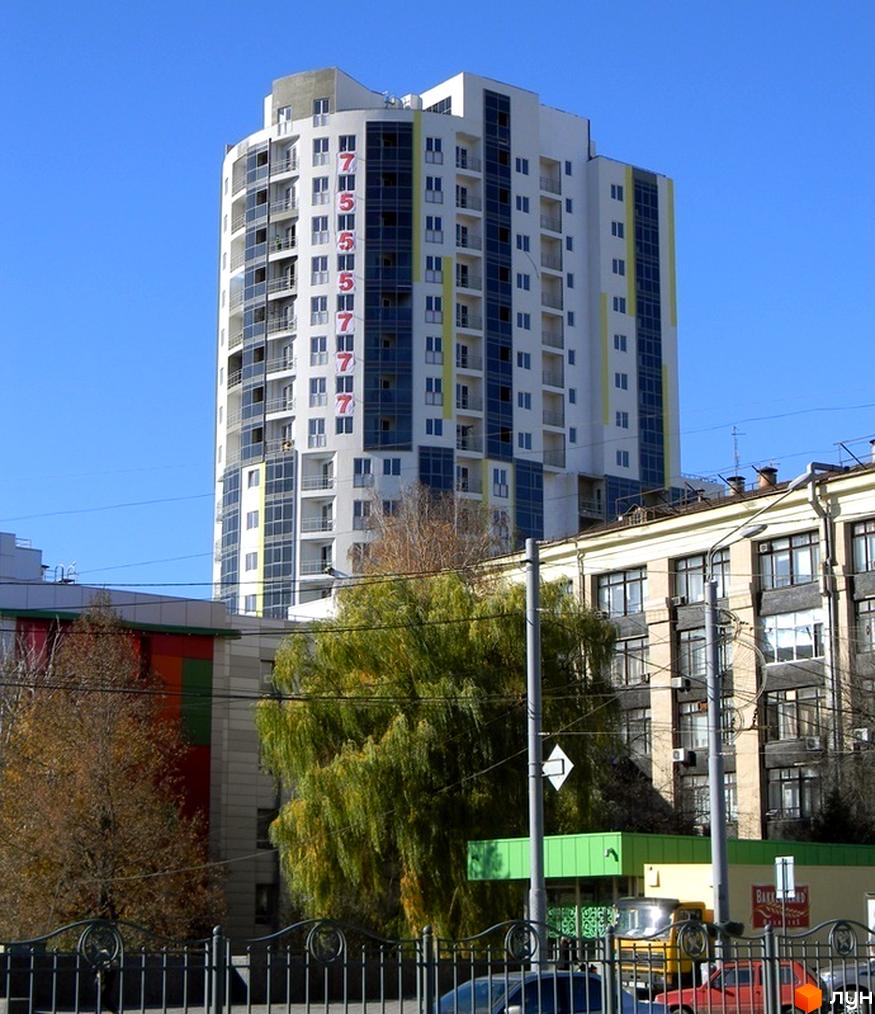 Житловий комплекс Аксіома - висотна біла будівля з синіми вікнами та червоними цифрами