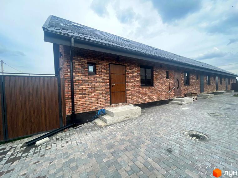 Котеджне містечко Одноповерховий Київ - Віта-Поштова. Зовнішній вигляд будинку з цегляною кладкою та вимощеною територією.