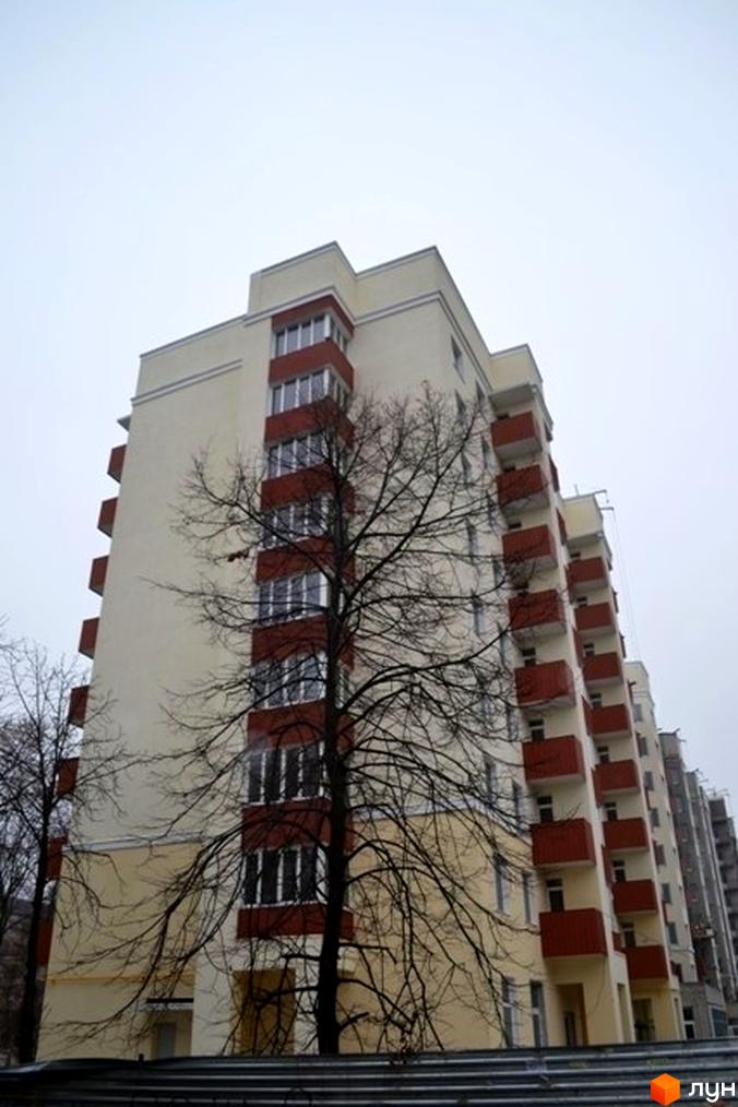 Житловий комплекс просп. Архітектора Альошина, 5. Висока будівля з балконами та прибудинковою територією з деревами.