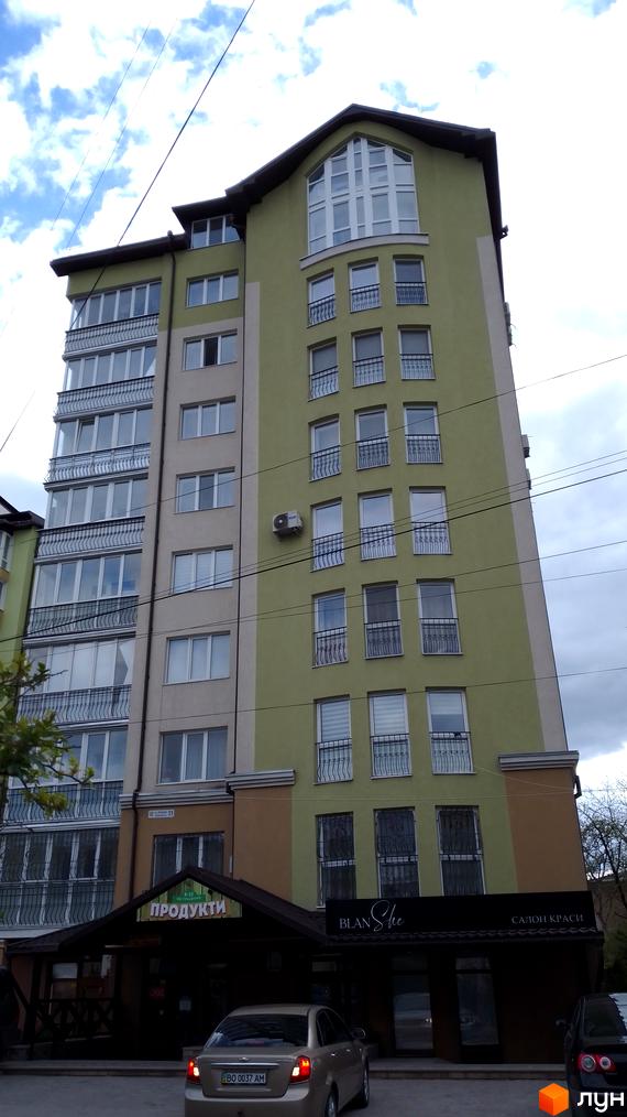 Зовнішній вигляд багатоповерхового будинку на вулиці Вояків Дивізії Галичина. Фасад будівлі світлих тонів з великими вікнами та балконами.