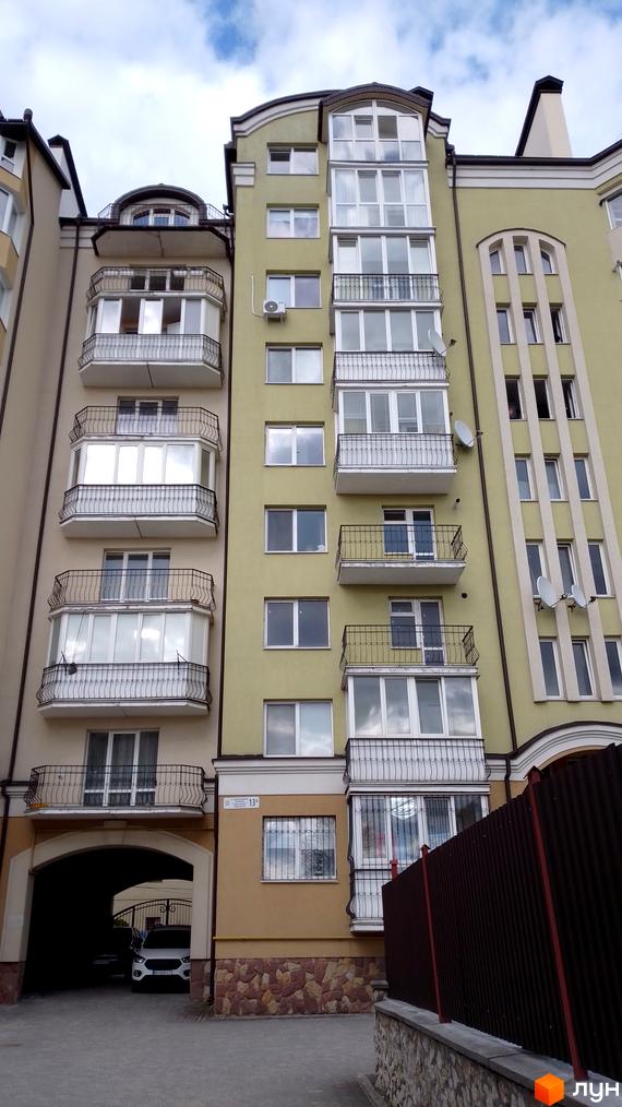 Зовнішній вигляд будинку на вулиці Вояків Дивізії Галичина. Багатоповерхова будівля з балконами та великими вікнами.