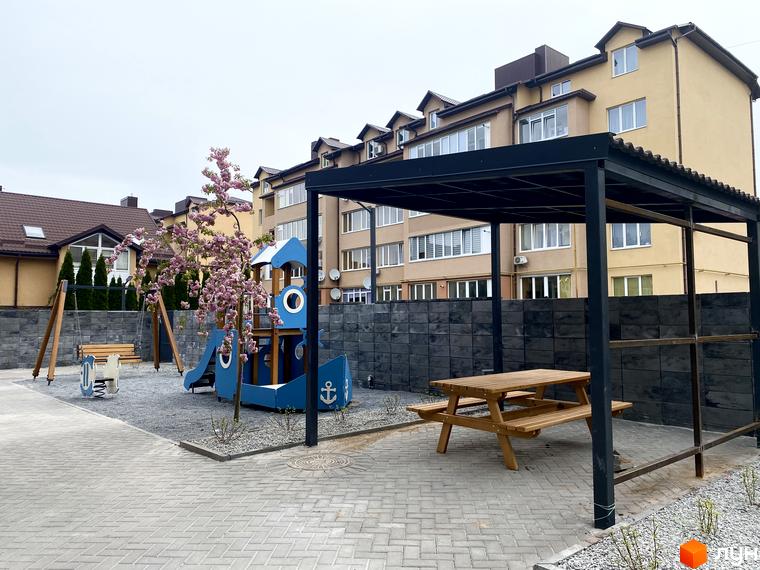 Клубний будинок „Васильченка“ з дитячим майданчиком та зоною відпочинку. Зовнішній вигляд новобудови та прибудинкової території.