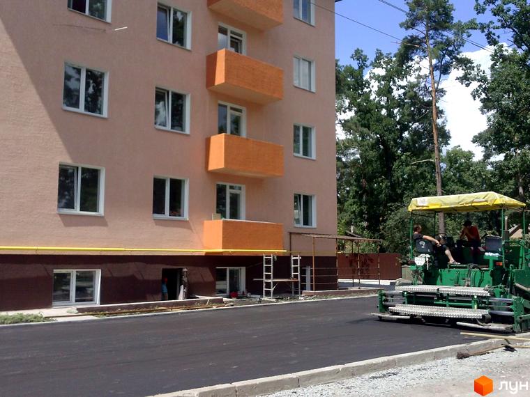 Зовнішній вигляд будинку на вул. Українська, 85в з балконами та новою прибудинковою територією, де тривають будівельні роботи.