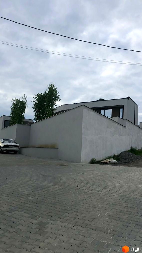 Зображення фасаду будинку Житловий комплекс на вулиці Собранецька, 60. Видно парковку з бруківкою та частину прибудинкової території.