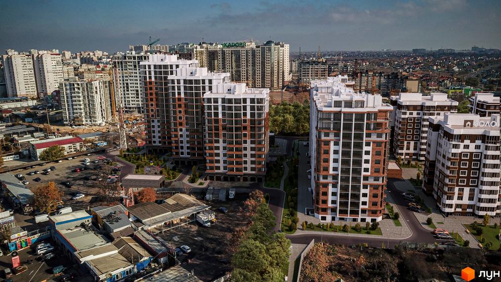 Житловий комплекс Золота Ера з висотними будинками з білими та коричневими фасадами. На території є парковка та зелені насадження.