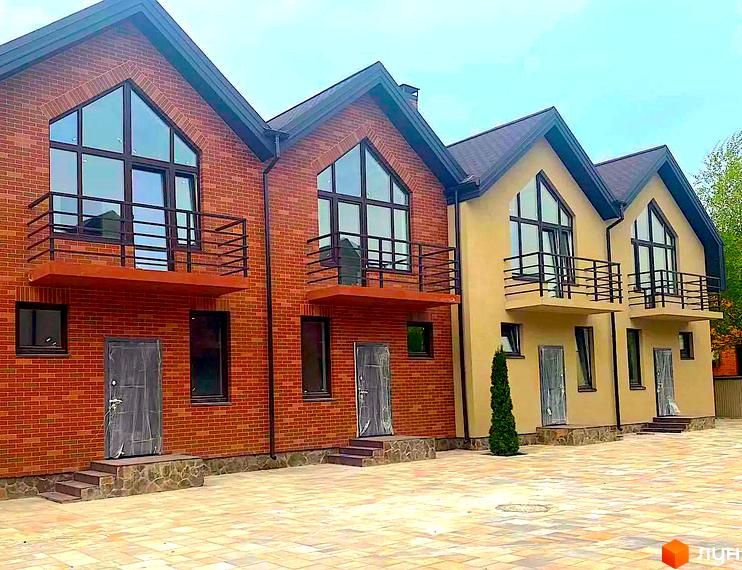 Зображення фасаду таунхаусів Modern House з великими вікнами та балконами. Територія перед будинками викладена плиткою.