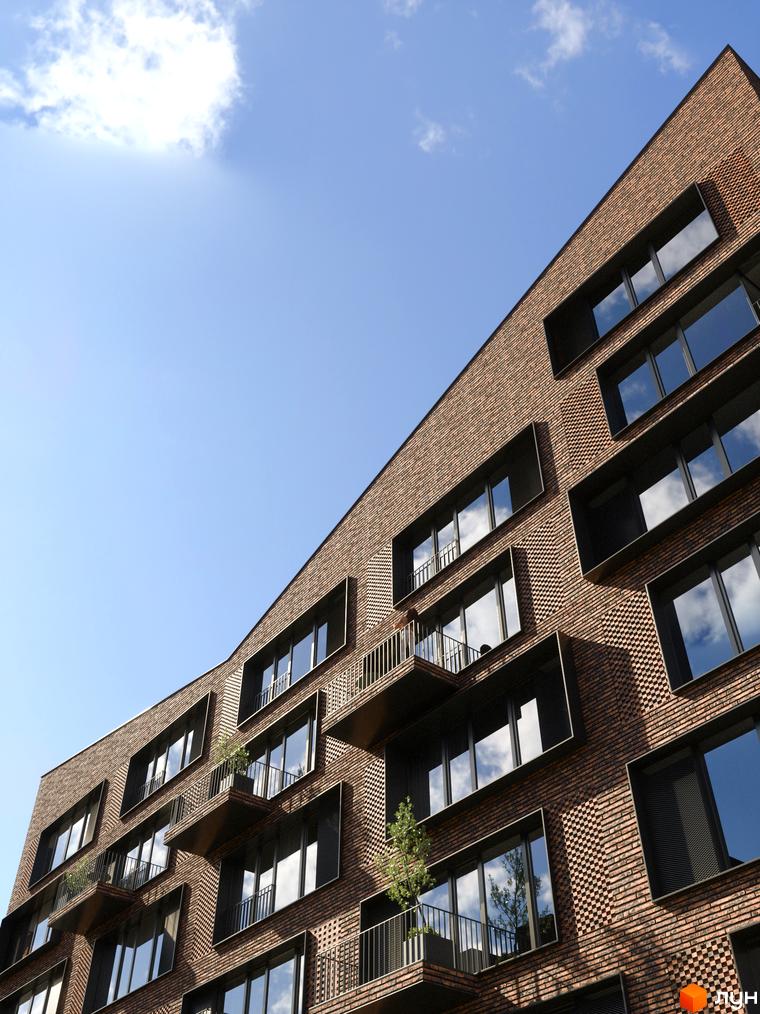Житловий комплекс MAVERICK з цегляним фасадом та панорамними вікнами на фоні блакитного неба. На балконах є рослини, що додають затишку.