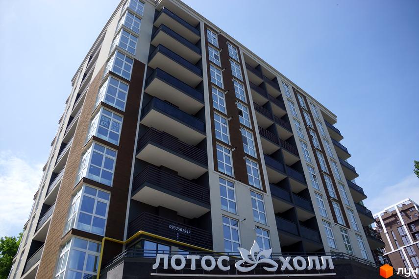 Зовнішній вигляд новобудови ЖК Лотос Холл, з численними балконами та великими вікнами. Будинок розташований на фоні блакитного неба.