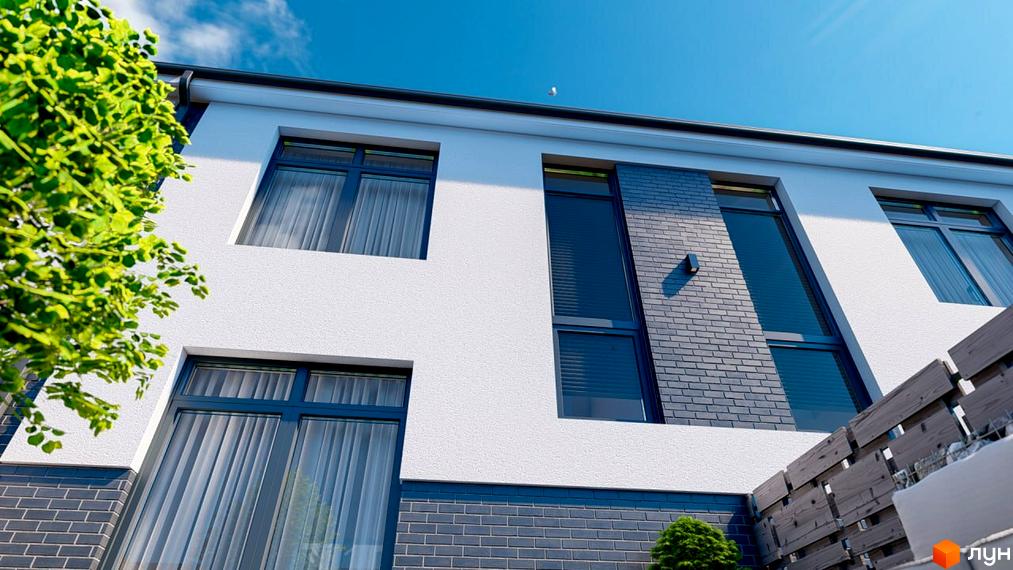 Фасад будинку в ЖК Таунхауси Kulbaba Bilogorodka з білими стінами, темними вікнами та цегляним декором. На передньому плані зелень та дерев'яний паркан.