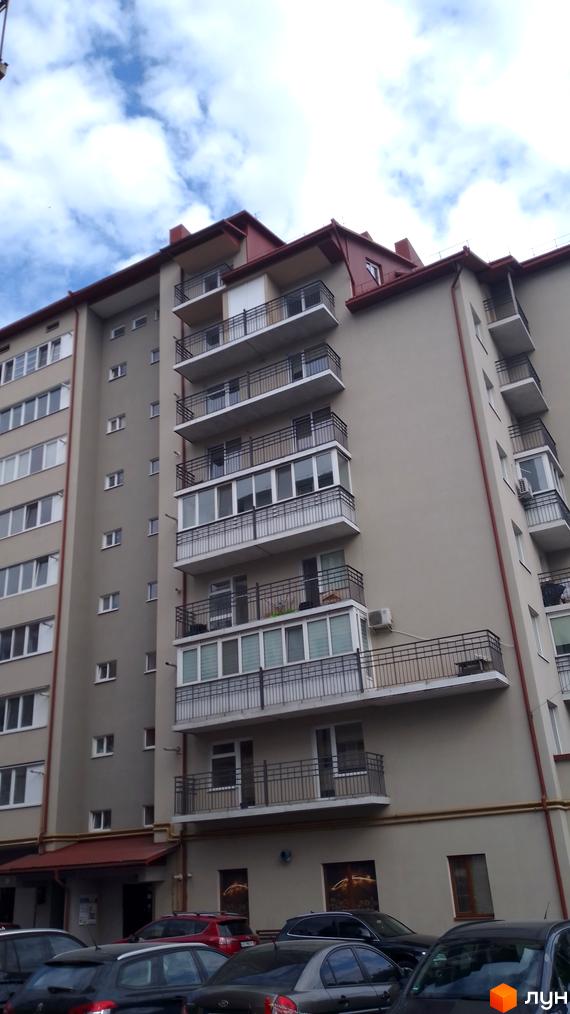 Зовнішній вигляд багатоповерхового будинку за адресою вул. Крушельницької, 53-55. Будинок має світло-сірий фасад, червоний дах та численні балкони з металевими огорожами. На передньому плані видно припарковані автомобілі.