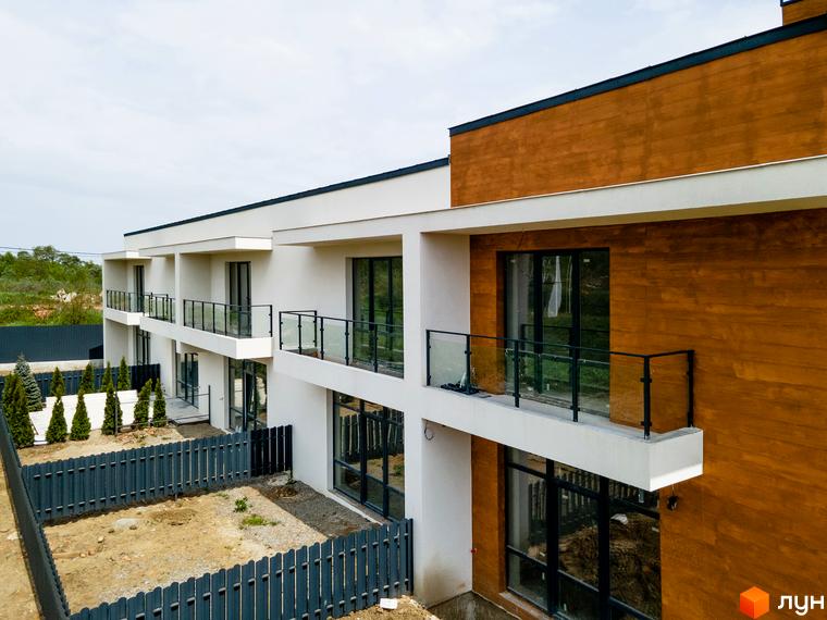 Котеджне містечко КМ City Villa Club: двоповерхові будинки з балконами та терасами, огороджена територія з деревами.