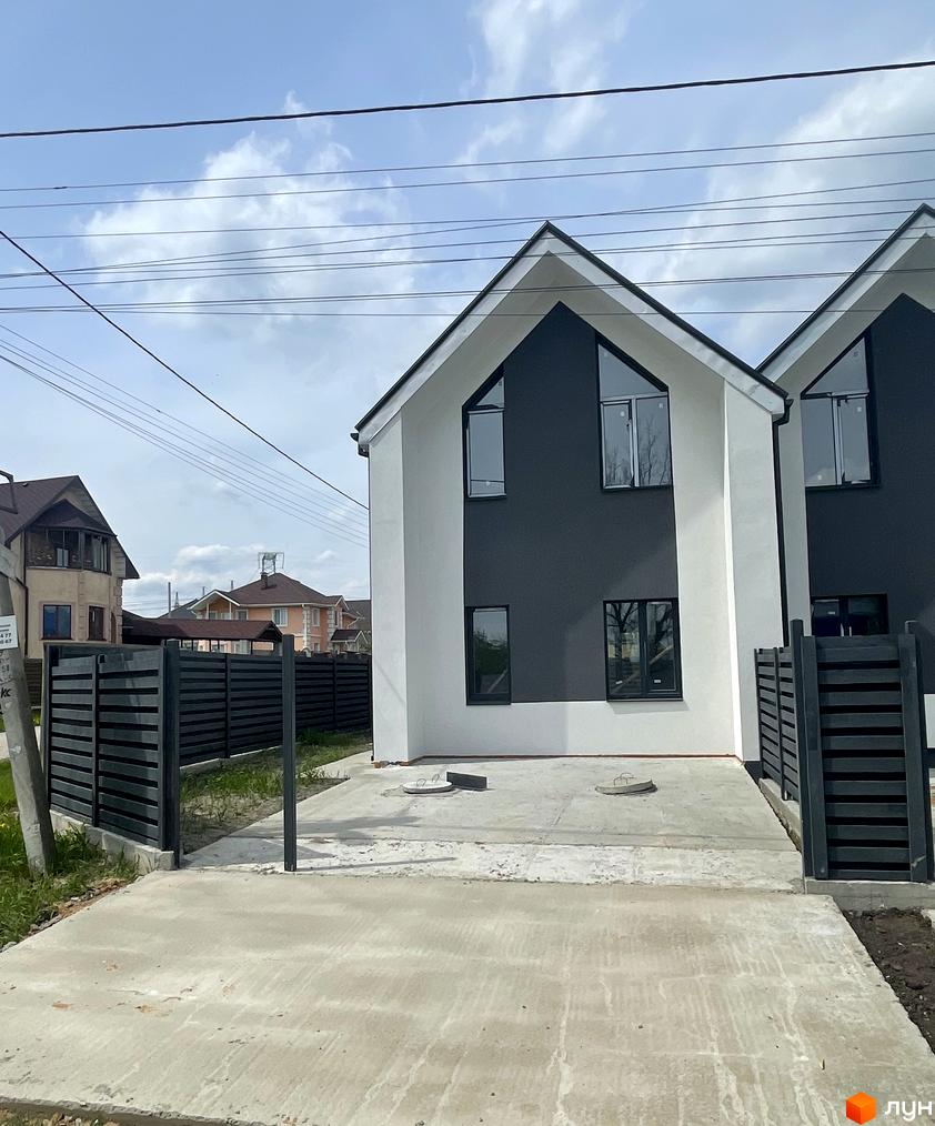 Дуплекси „На Зоряному“: двоповерхові будинки з темними та світлими фасадами, великими вікнами та чорними парканами. Прибудинкова територія з бетонним покриттям та зеленню.