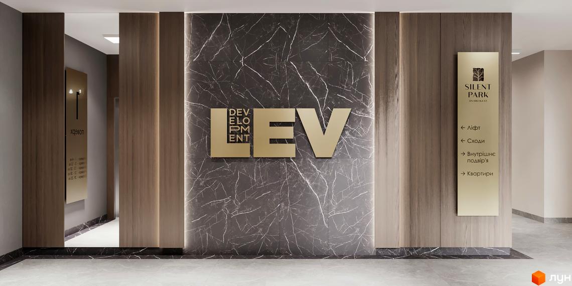 Новобудова SILENT PARK з золотистою вивіскою та мармуровим оздобленням стін. Навігаційна табличка вказує напрямок до ліфта, сходів та квартир.