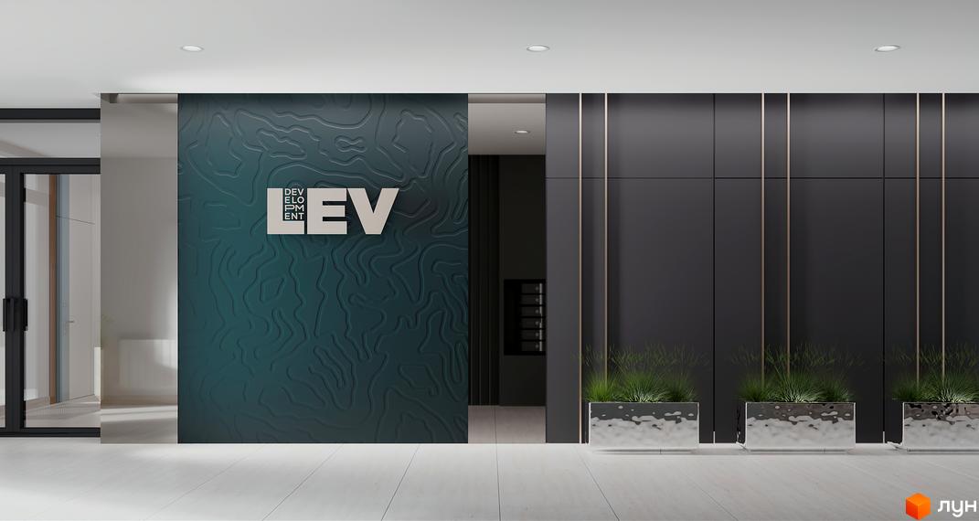 Сучасний вхід у житловий комплекс FEEL HOUSE з брендингом компанії та зеленню в зоні очікування.