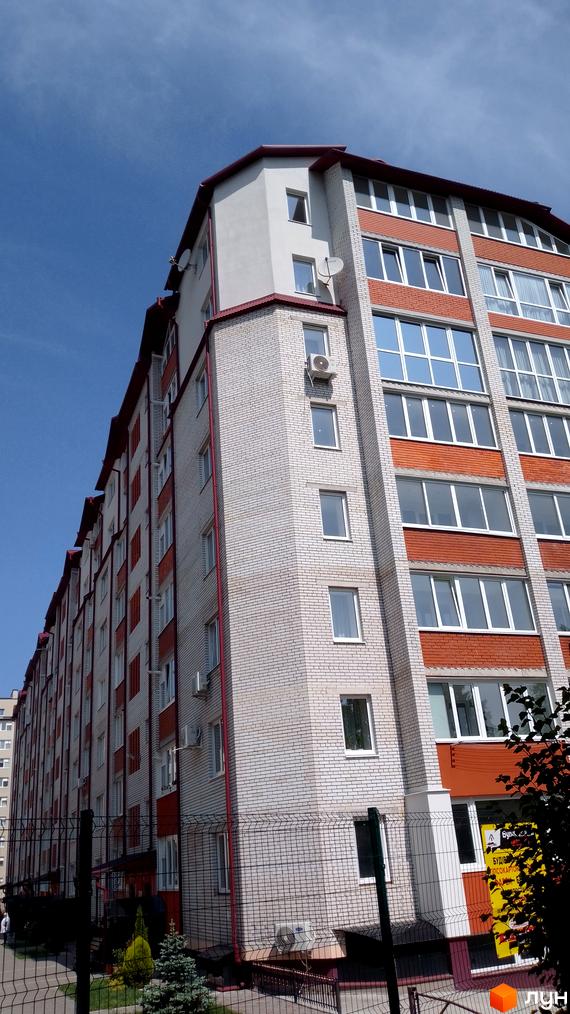 Багатоповерховий житловий будинок з білої та червоної цегли, розташований на вул. Рєпіна, 34. Навколо будинку є огорожа та зелені насадження.