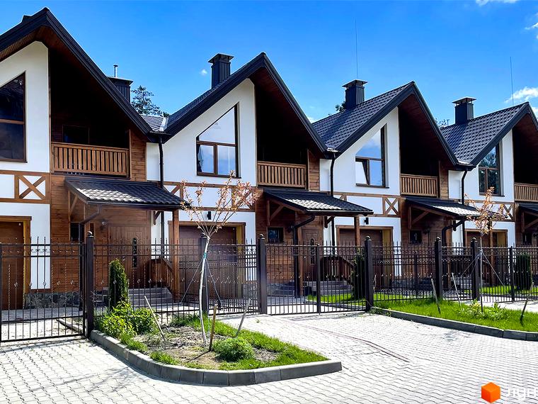 Таунхауси Desna Residence-2: ряд будинків з темними дахами, білими фасадами, дерев'яними балконами та огорожею.