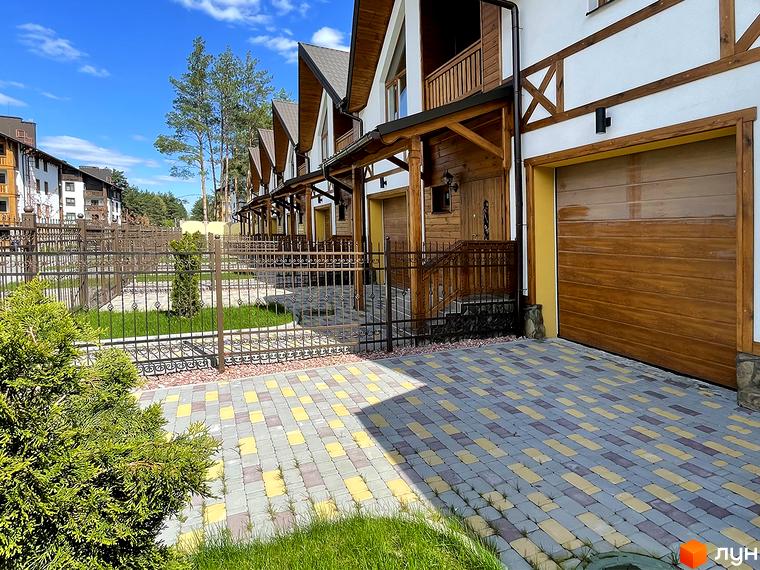 Ряд таунхаусів Таунхауси „Desna Residence-2“ має білі фасади з дерев'яними балками та коричневими дахами. Прилегла територія облаштована бруківкою та зеленим газоном.