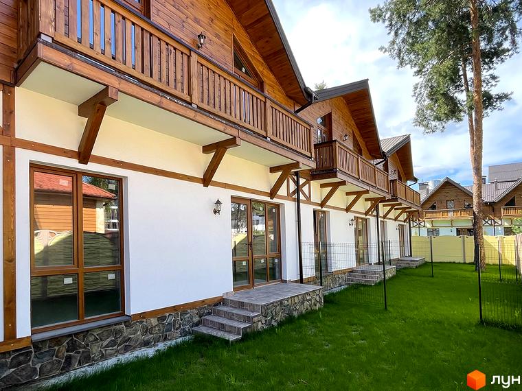 Ряд таунхаусів Desna Residence-2 з дерев'яними балконами та білими фасадами. Перед будинками доглянутий газон.
